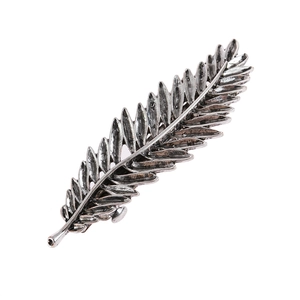 Vintage silver feather hair clip with detailed leaf texture and bohemian style on white background