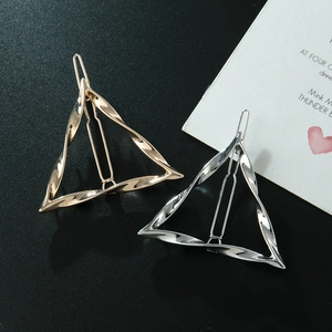Dettaglio di fermagli per capelli a triangolo vuoto intrecciato in oro e argento su fondo