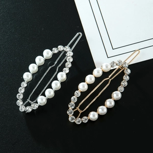Vue détaillée des pinces à cheveux ovales en or et argent avec perles et strass