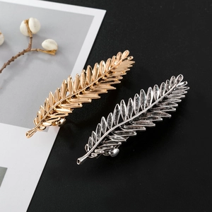 Vintage metal leaf hair clips in gold and silver set on a minimalist elegant background