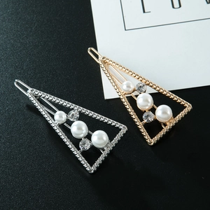 Details von gedrehten Haarspangen in Gold und Silber mit weißen Perlen und Strasssteinen