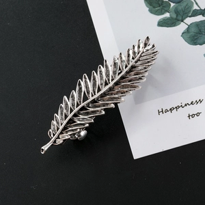Detailed macro view of vintage silver feather hair clip with realistic leaf texture