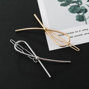 Polished metal bow hair clips in gold and silver finish for women’s hairstyling