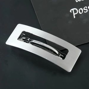 Macro shot of silver rectangle hollow hair clip with brushed metal texture and spring