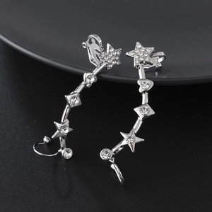 Close-up of silver star earrings with sparkling rhinestones and a curved clip-on design