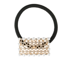 Detailed macro shot of a geometric gold ponytail holder with pearls and rhinestones