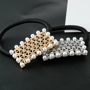 Close-up of gold and silver square hair ties with mesh pattern and pearls