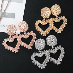 Three pairs of heart-shaped drop earrings in gold, silver, and rose gold with hammered texture