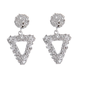 Detail of silver geometric earrings with unique hammered texture and lava metallic finish