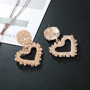Detail of heart drop earrings with gold hammered texture showing front and back view