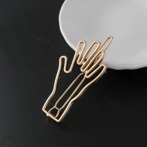 Barrette à cheveux minimaliste dorée en forme de main avec le doigt d'honneur