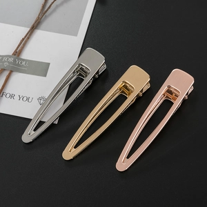 Three minimalist matte brushed metal duckbill hair clips in gold, silver, and rose gold