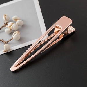 Minimalist long duckbill hair clip in rose gold finish with brushed metal texture