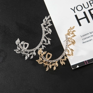 Detailed macro view of hollow leaf ear cuffs featuring sparkling crystals in gold and silver