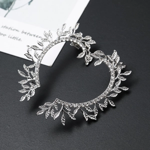 Macro shot of sparkling crystal leaf earrings on a black background with elegant details