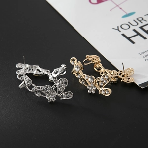 Détail de boucles d'oreilles papillon argent et or avec motif de cristaux pavés