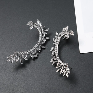 Close-up of silver hollow leaf ear cuffs featuring sparkling inlaid rhinestones detail