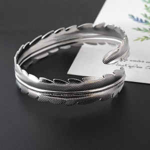 Dettaglio del bracciale da braccio a foglia di piuma argento con trame metalliche rifinite