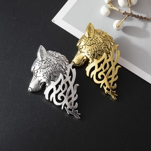 Detailed macro view of vintage gold and silver wolf head lapel pins with totem carvings