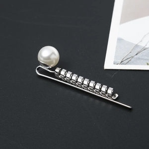 Elegant silver metal twist hair clip featuring a white pearl on a sleek black background