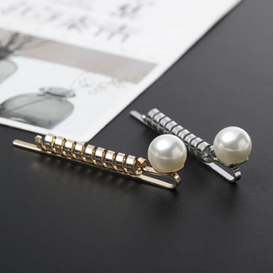 Detailed macro view of spiral twist metal hair pins with large white pearls