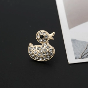 Exquisite gold-plated duck brooch with sparkling white crystals on a black background