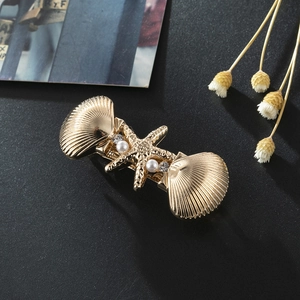 Pince à cheveux élégante étoile de mer et coquillages dorés avec perles sur fond noir mat