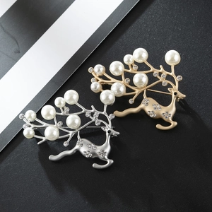 Detail of elegant gold and silver reindeer brooches with white pearls and crystals