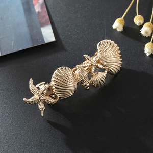 Golden ocean theme hair clip with textured starfish and seashell metallic motifs