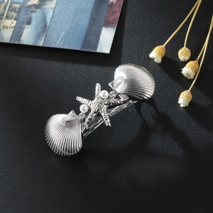 Détail de la pince à cheveux étoile de mer argentée avec coquillages, perles et strass