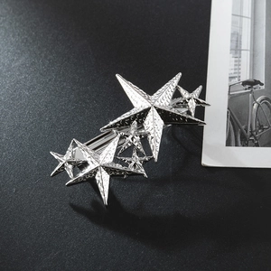 Macro detail of silver star hair clip showing hammered alloy texture and star design