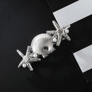 Macro detail of starfish and shell hair clip with silver finish and pearls