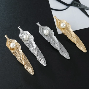 Elegant gold and silver feather hair clips with white pearls and textured finish