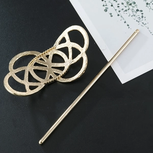 Macro detail of matte gold hollow geometric hair pin with elegant brushed texture