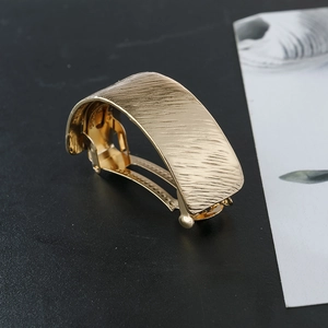 Matte champagne gold rectangular arched ponytail clip with brushed metal texture surface