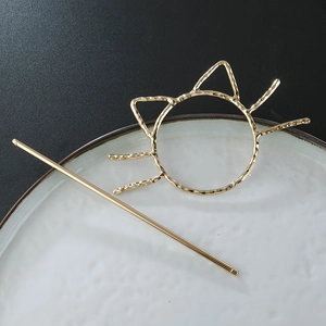 Macro view of golden alloy cat hair pin with textured hammer finish in a ceramic tray