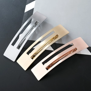 Close-up of three brushed metal rectangular hair clips in silver, gold and rose gold