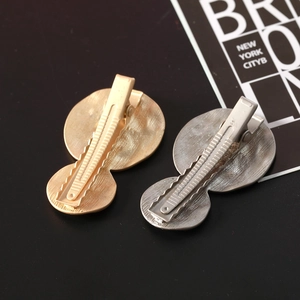 Detailed macro view of metal duckbill clips with matte textured gold and silver finish
