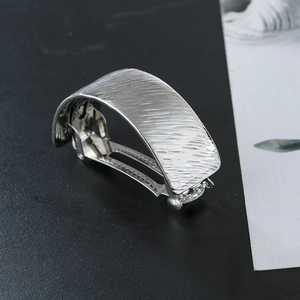 Detail of silver alloy ponytail clip with a unique matte brushed texture and spring mechanism