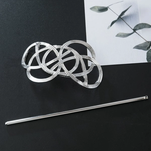 Close-up of vintage hollow silver hair stick set on a stylish textured background