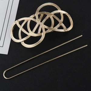 Macro view of gold minimalist hollow hair clip and matching U-shaped hairpin set