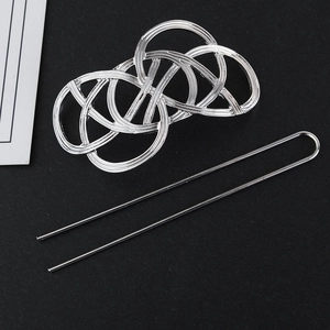 Detail view of silver Celtic knot hair pin and U-shaped hair stick on black texture