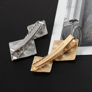 Detail of metal hair clips with brushed texture and irregular double rhombus design