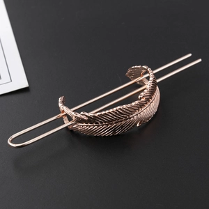 Detail shot of the rose gold leaf hair pin featuring textured feather patterns and twin prongs