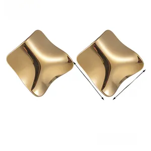 Detail of gold titanium steel earrings with irregular concave surface and mirror finish