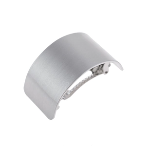 Macro detail of silver arched metal hair clip showing brushed texture and spring mechanism