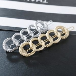 Close-up of interlocking matte alloy chain hair clips in gold and silver finishes