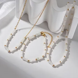 Elegante collana di perle di bambù con sfere in metallo dorato e chiusura a moschettone
