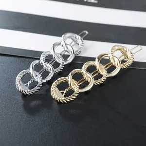 Detail of linked metal rings hair clip in gold and silver finish with chain texture