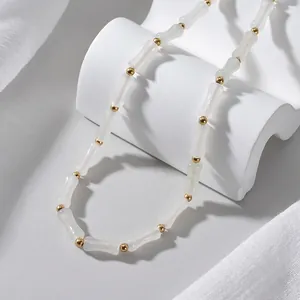 Elegante collana di perle di bambù con distanziali dorati su supporto geometrico bianco